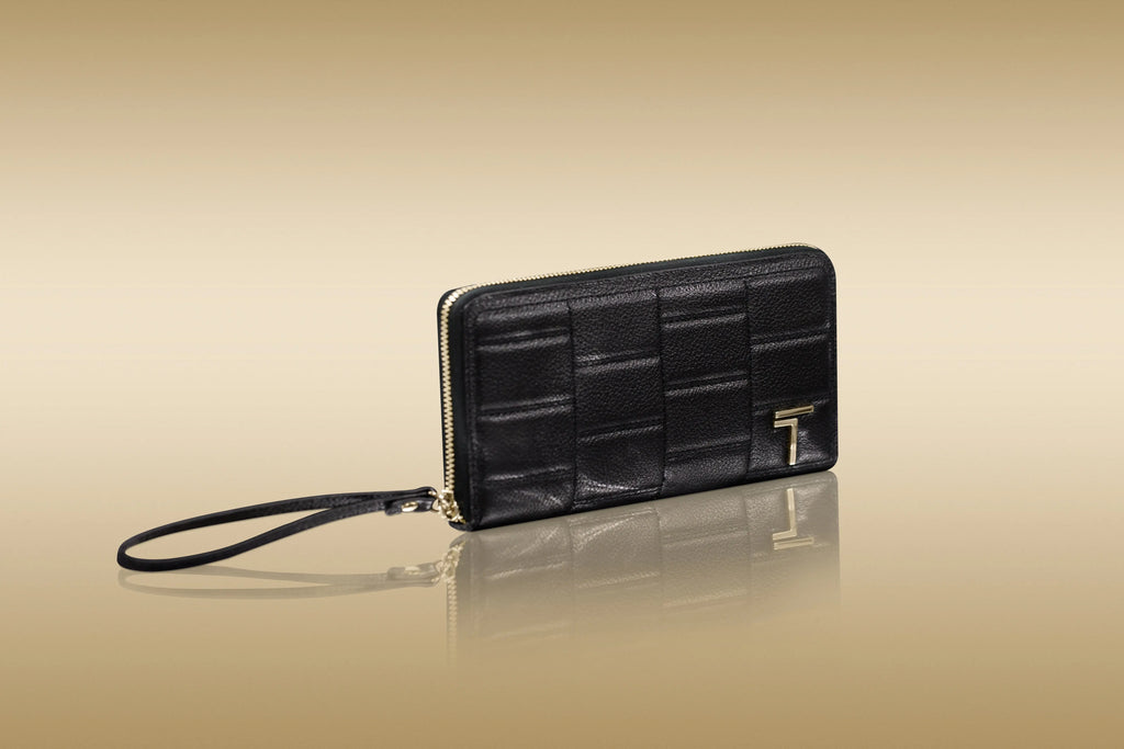  black Trevony zipped wallet with a wrist strap and a gold 'T' emblem displayed against a reflective golden background.