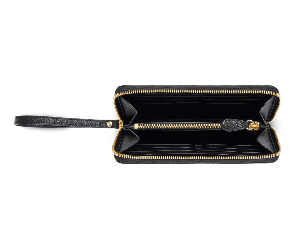 The interior of a black lambskin Trevony Intima long wallet, displayed open with gold-tone zippers, revealing multiple card slots and compartments.