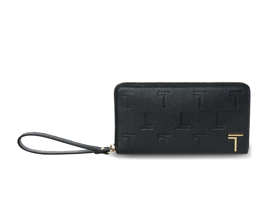 A black lambskin leather long wallet with an embossed monogram pattern and a wrist strap, featuring a gold-tone metal logo and hardware. 
